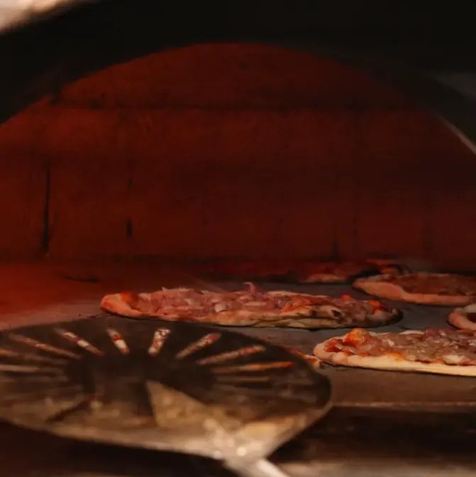 Forno a legna acceso con pizze artigianali in cottura al Ristorante La Fenice di Bazzano